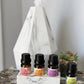 Set of essential oil bottles on a marble stand with a diffuser in the background.